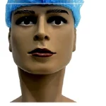 Close-up of a plastic mannequin head wearing a blue surgical cap, facing forward.